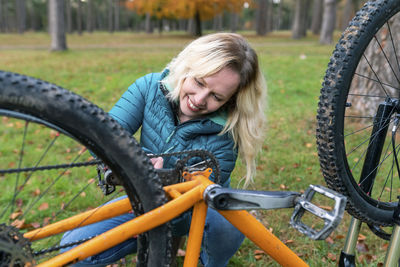 Side view of smiling woman with bicycle
