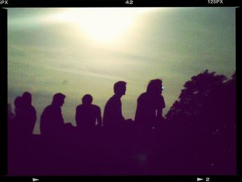 People standing on landscape at sunset
