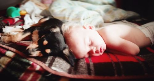 Close-up of baby sleeping on bed at home