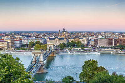 View of budapest with st. stephen's basilica and szechenyi chain bridge at sunset, hungary