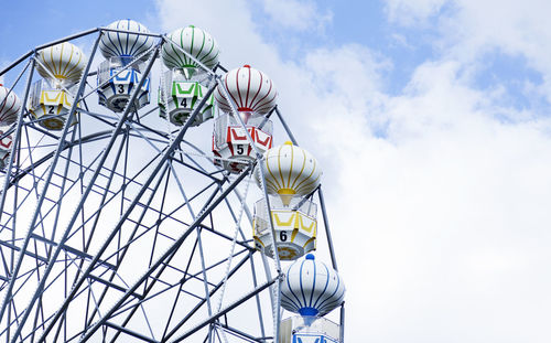 Part of ferris wheel against blue sky