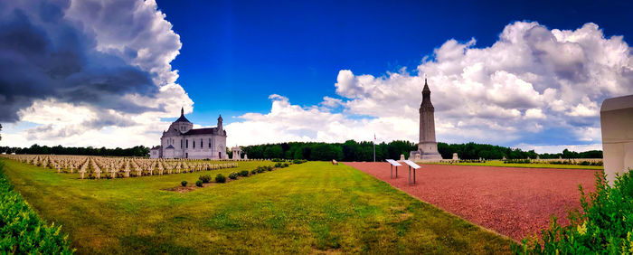 Panoramic view of buildings against cloudy sky