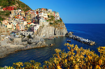 Scenic view of town by sea against clear sky