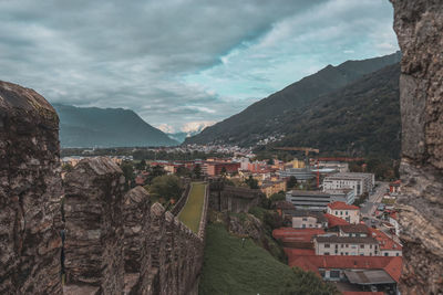 Town on mountain against cloudy sky