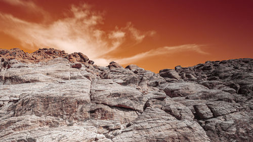 Rock formation on land against sky during sunset