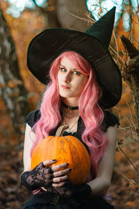 Portrait of beautiful young woman holding pumpkin