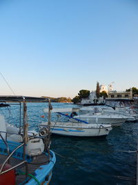 Boats sailing in sea against clear blue sky