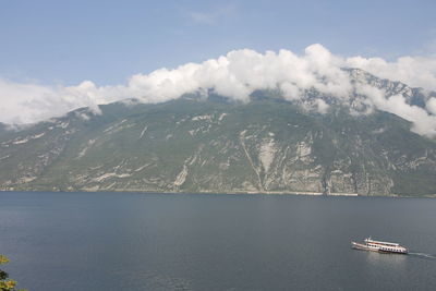 Scenic view of sea by mountains against sky