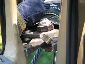 Low section of man working on motorcycle