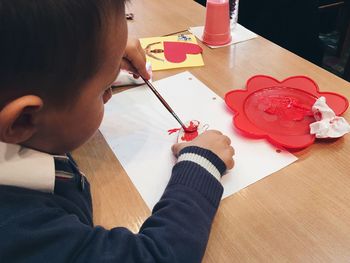 Close-up of boy making drawing on desk