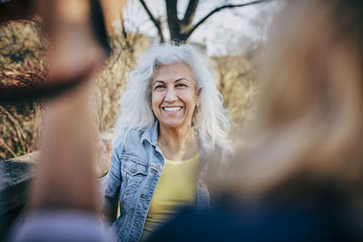 Portrait of smiling senior woman with friends at park