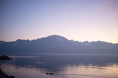 Scenic view of lake and mountains against clear sky