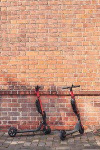 Push scooters against brick wall