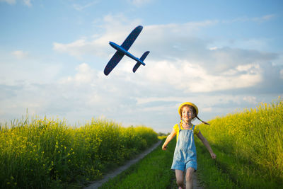 Woman standing on field against sky