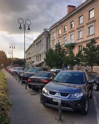 Cars on road against sky in city