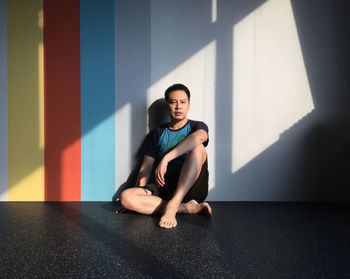 Young woman sitting on wall