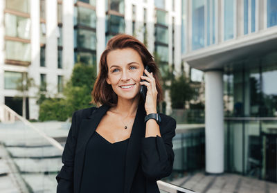 Businesswoman talking on mobile phone in city