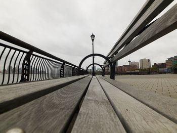 Surface level of bridge against sky in city