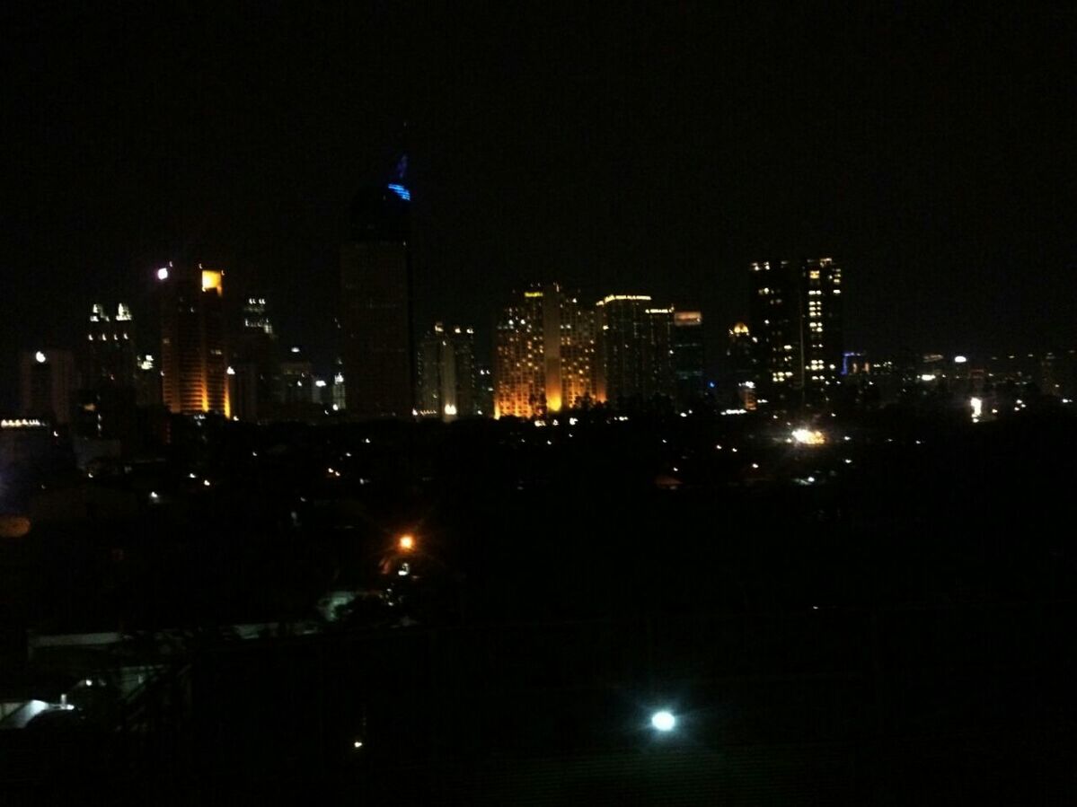 night, illuminated, city, building exterior, architecture, cityscape, skyscraper, built structure, modern, urban skyline, tall - high, office building, tower, dark, city life, crowded, financial district, sky, clear sky, tall