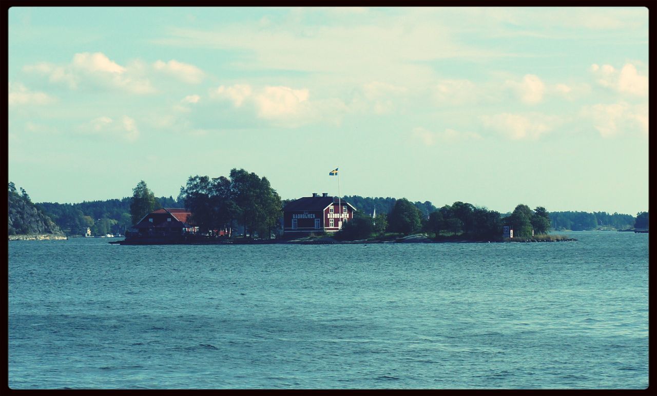 transfer print, built structure, architecture, water, building exterior, auto post production filter, sky, waterfront, river, tree, cloud - sky, sea, rippled, cloud, house, nature, scenics, outdoors, town, no people