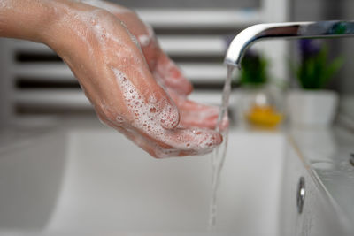 Close-up of person hand on wet table