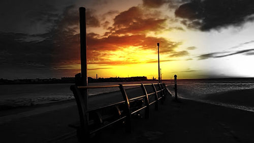 Empty beach against sky during sunset