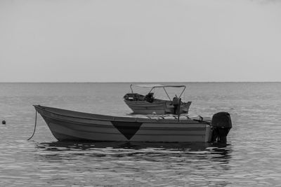 Boat moored in sea against clear sky