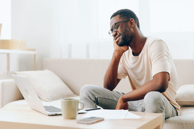 Young man using laptop while sitting at home