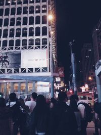 People on illuminated building at night