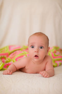 Portrait of cute baby lying on bed