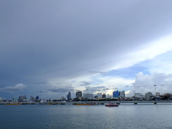 Sea by buildings against sky