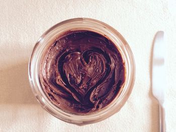 Directly above shot of heart shape made on chocolate in container