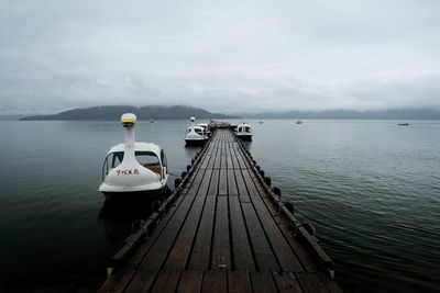 Motorboats moored at pier on caldera lake at akan national park