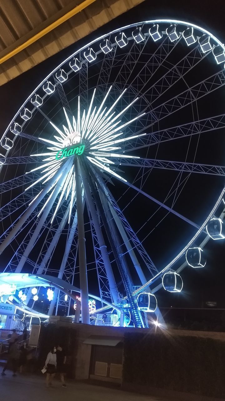 LOW ANGLE VIEW OF ILLUMINATED FERRIS WHEEL AGAINST BLUE SKY