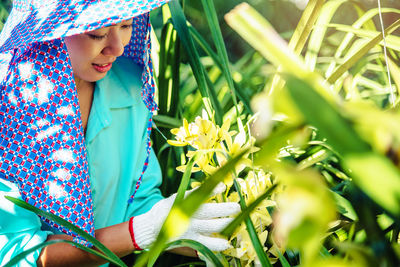 Female researcher examining plants in greenhouse