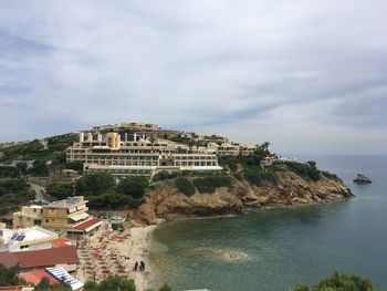 Scenic view of sea by cliff against sky