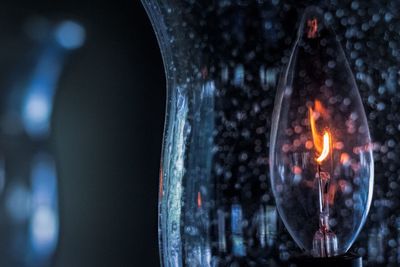 Close-up of lit candle in the dark