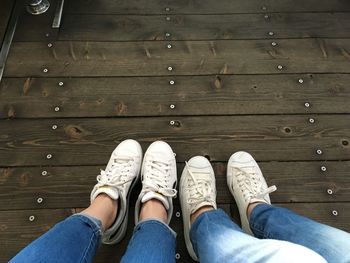 Low section of person standing on wooden floor