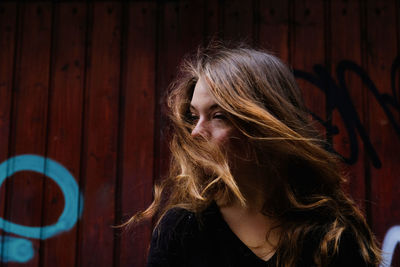 Portrait of woman standing against wall