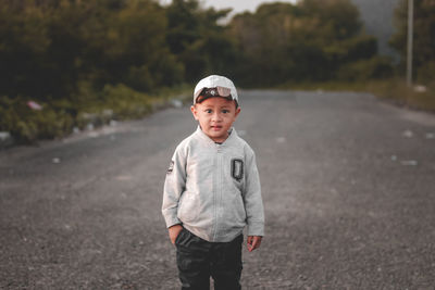 Portrait of young man standing on road
