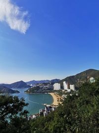 Scenic view of sea and buildings against blue sky