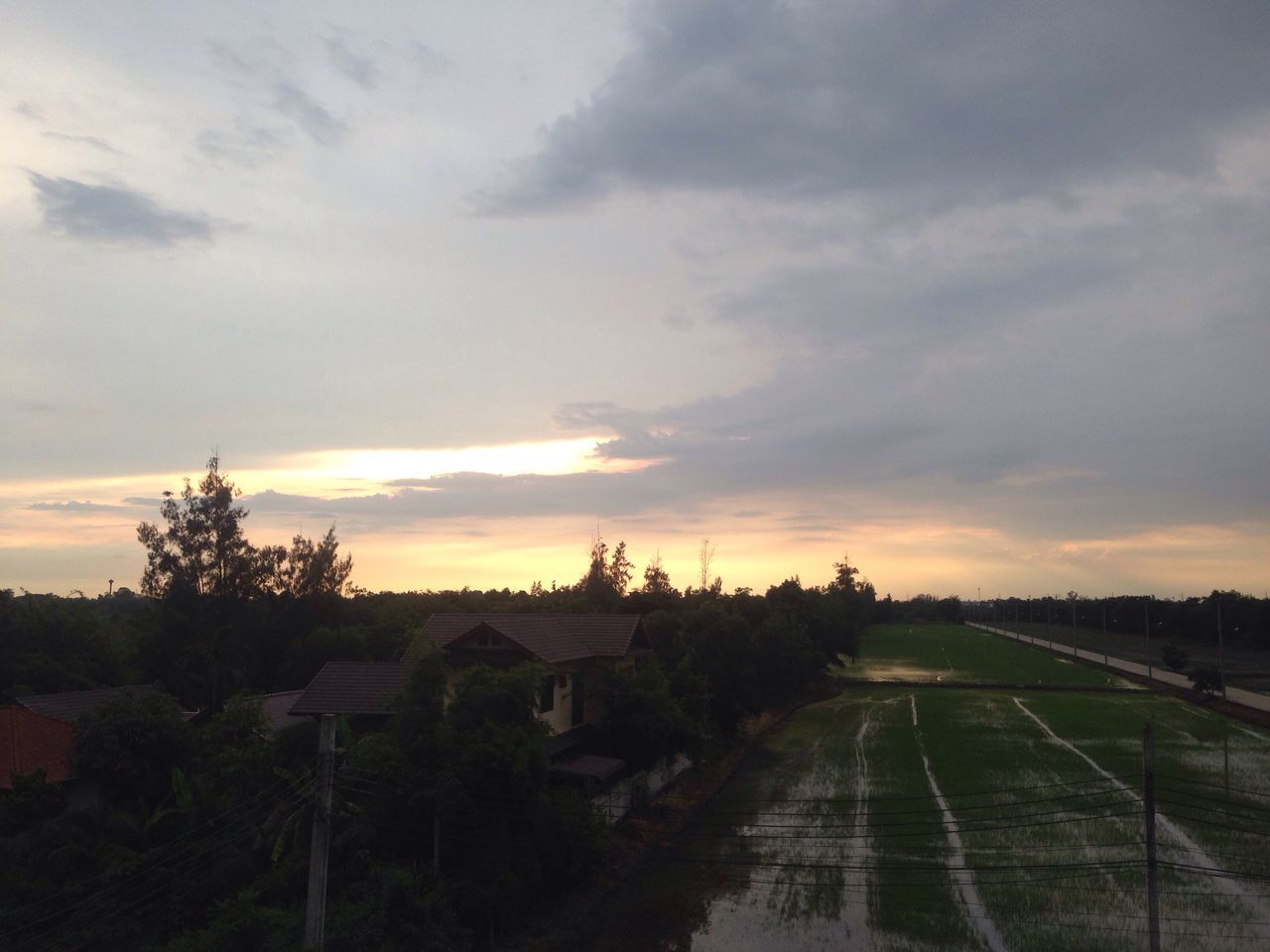 sky, sunset, cloud - sky, cloudy, rural scene, landscape, field, weather, cloud, nature, tranquil scene, tranquility, scenics, beauty in nature, overcast, dramatic sky, outdoors, orange color, no people, growth, the way forward, plant, idyllic, village, moody sky, horizon over land