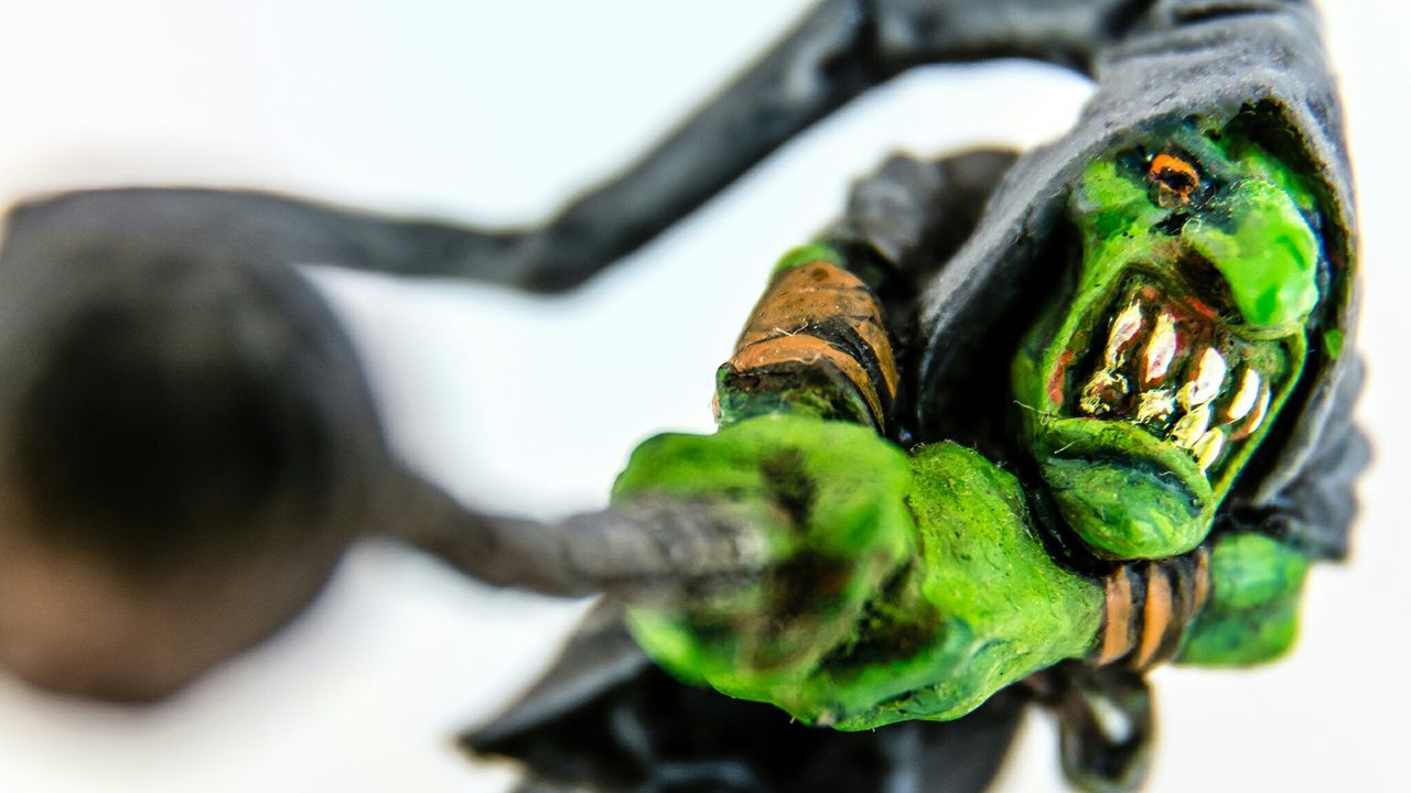 selective focus, close-up, focus on foreground, green color, metal, still life, indoors, focus on background, day, art and craft, high angle view, no people, art, metallic, part of, shoe, cultures, human representation, creativity