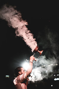 Rear view of woman holding sparkler at night