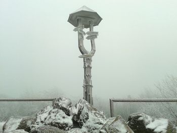 Traditional windmill against sky during winter