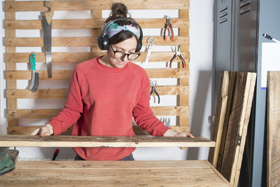 Woman holding wood at workshop