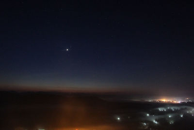 Aerial view of illuminated city against sky at night