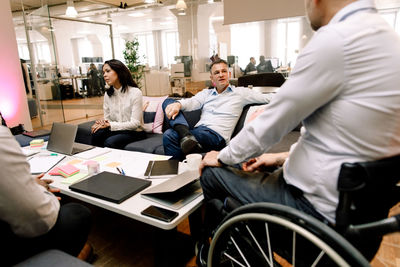 Manager talking with disabled businessman during meeting in office