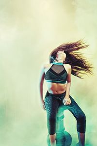 Full length of woman standing against wall