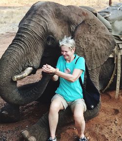 Full length of woman feeding elephant